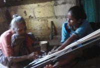 salah satu tahap dari proses kerja tenun ikat oleh perajin tenun ikat