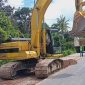 Alat berat excavator terlihat sibuk membongkar ruas jalan yang rusak di Desa Mandeu, Kabupaten Belu.