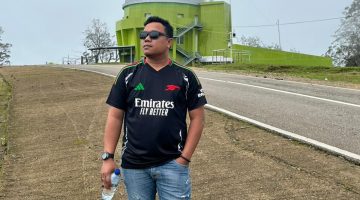 Foto Jurnalis Chris Bani dengan latar belakang Observatorium Timau 