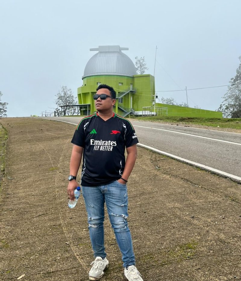 Foto Jurnalis Chris Bani dengan latar belakang Observatorium Timau 