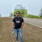 Foto Jurnalis Chris Bani dengan latar belakang Observatorium Timau 